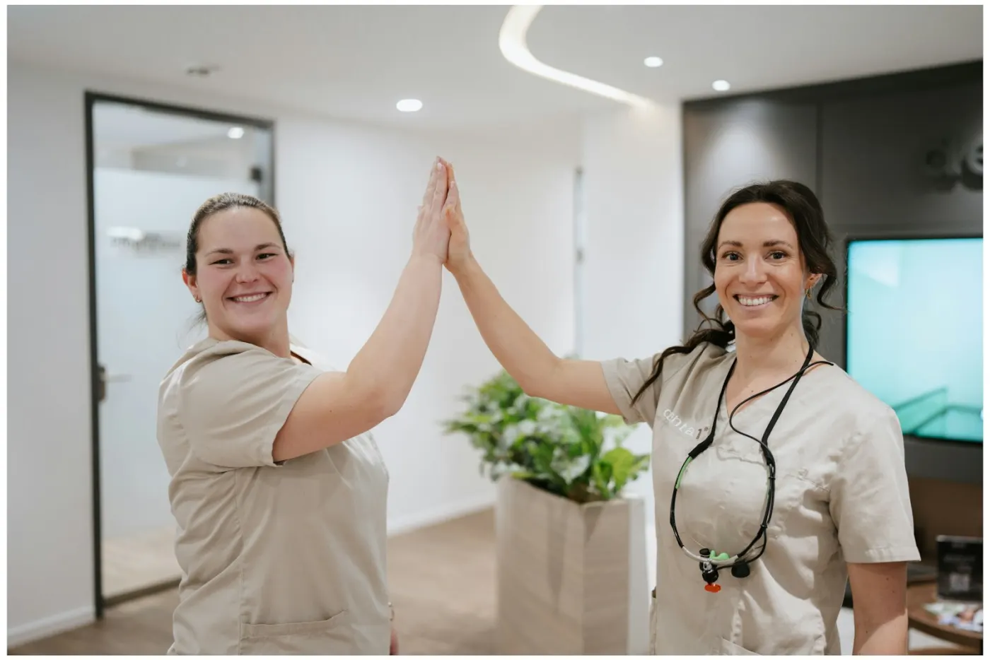 Zwei Kolleginnen der Denta1 Clinic klatschen sich ab